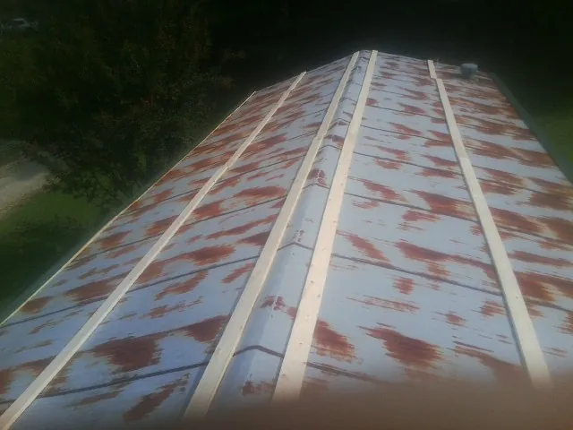 Rusted metal roof panels with new wood purlins before replacement — Storm Damage Roof Repair in Patterson by Roofing Brothers