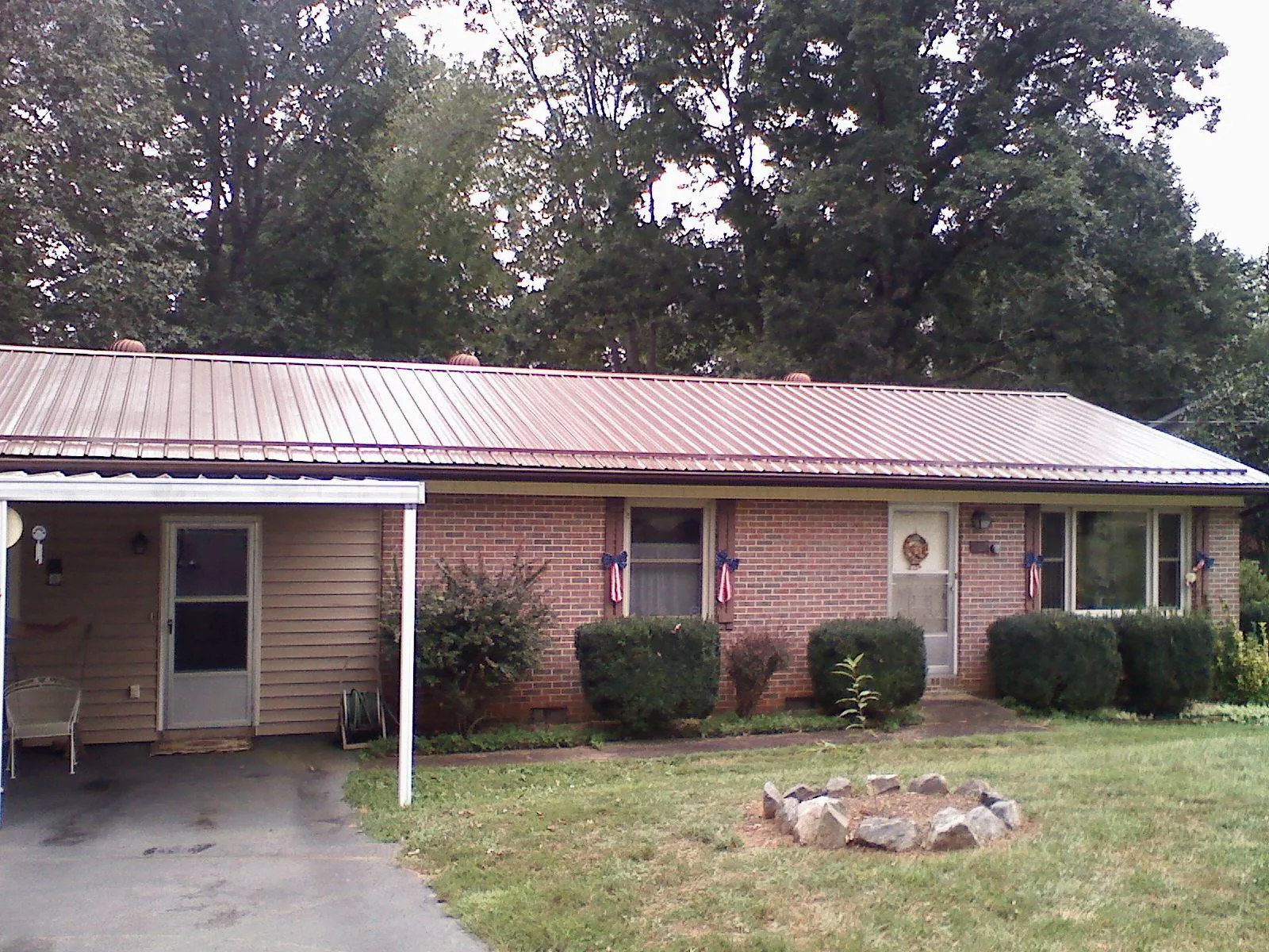 Bronze metal roof and carport on a brick ranch home — Roof Repair work by our crew in Patterson